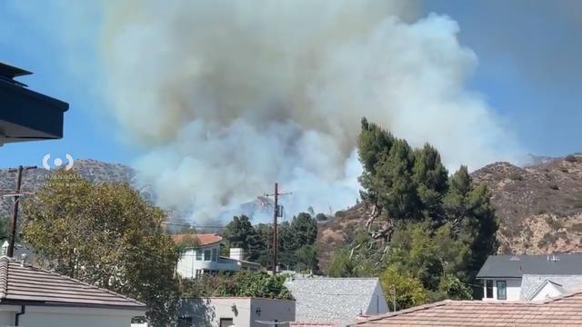 Fire crews are battling a brush fire on the hillside above Burbank, triggering evacuation orders...